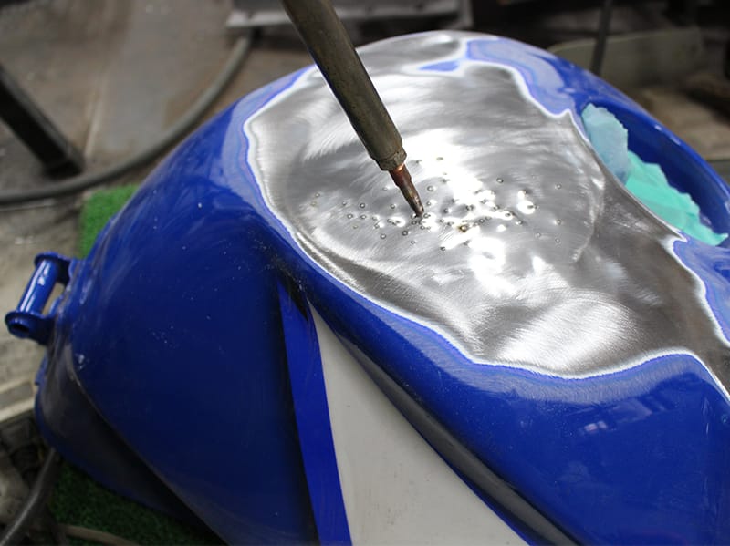 板金が必要な場合はスタット溶接機による凹みの引出です。タンク容量が少なくならない様、またパテの厚付けによる後のトラブルを防ぐため、凹みは極力出しておきます